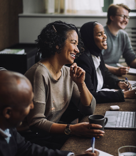 A group of colleagues working together while sitting at a table.